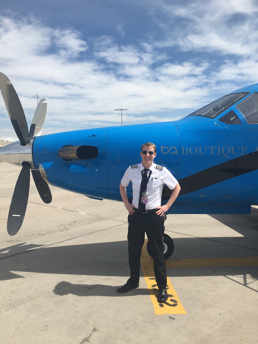 Ethan Collins, Boutique Air captain, on the ramp in front of a blue Pilatus PC-12